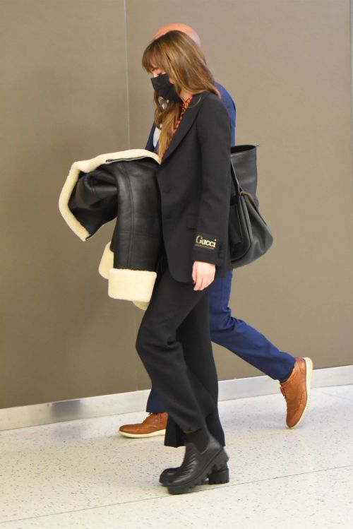 Dakota Johnson in Checked Shirt With Gucci Suits at JFK Airport in New York 4