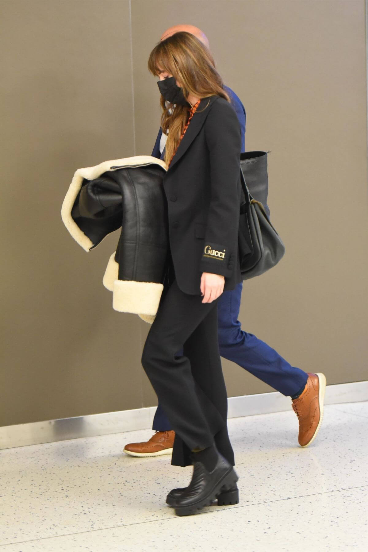 Dakota Johnson in Checked Shirt With Gucci Suits at JFK Airport in New York 6