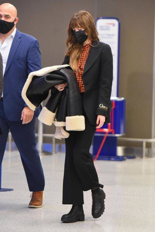 Dakota Johnson in Checked Shirt With Gucci Suits at JFK Airport in New York