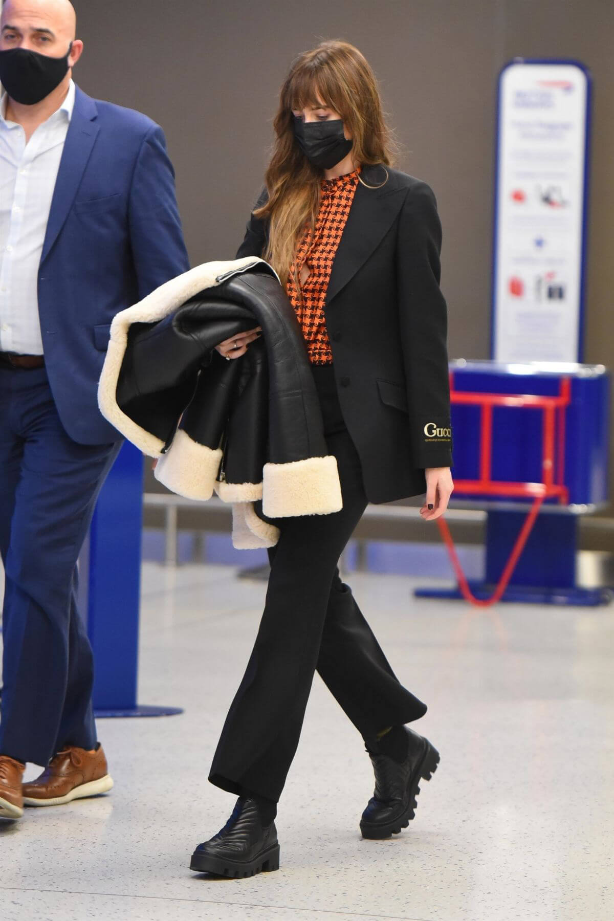 Dakota Johnson in Checked Shirt With Gucci Suits at JFK Airport in New York 3