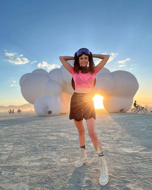 Nina Dobrev seen in Pink Top with Black Short Skirt at Burning Man Event
