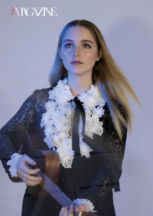 mckenna grace in a black dress and long boot