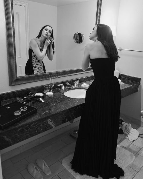 Mirror photography of Ana De Armas dressing up in bathroom for Golden Globes 2023, wearing a black and white long dress and silver bracelet