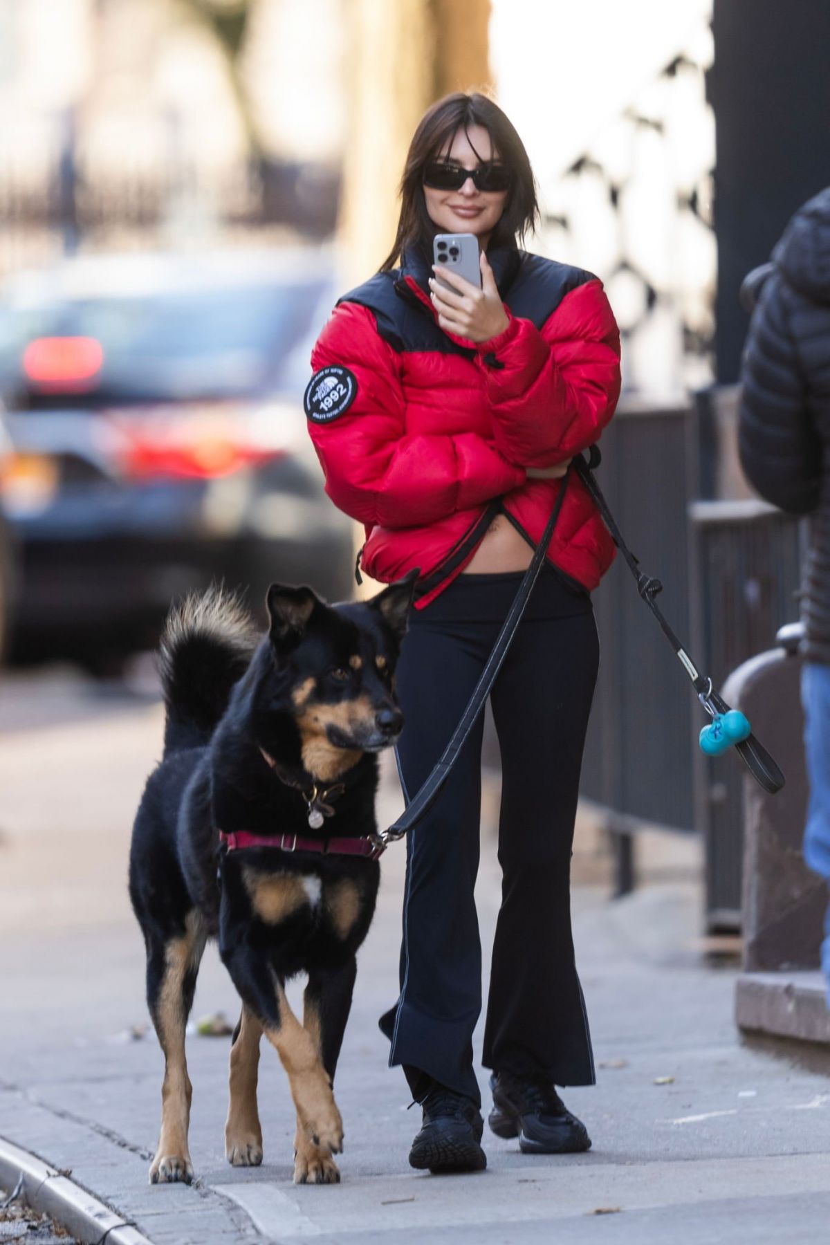 Emily Ratajkowski in Red Puffer & Black Pants While Walking Her Dog 3