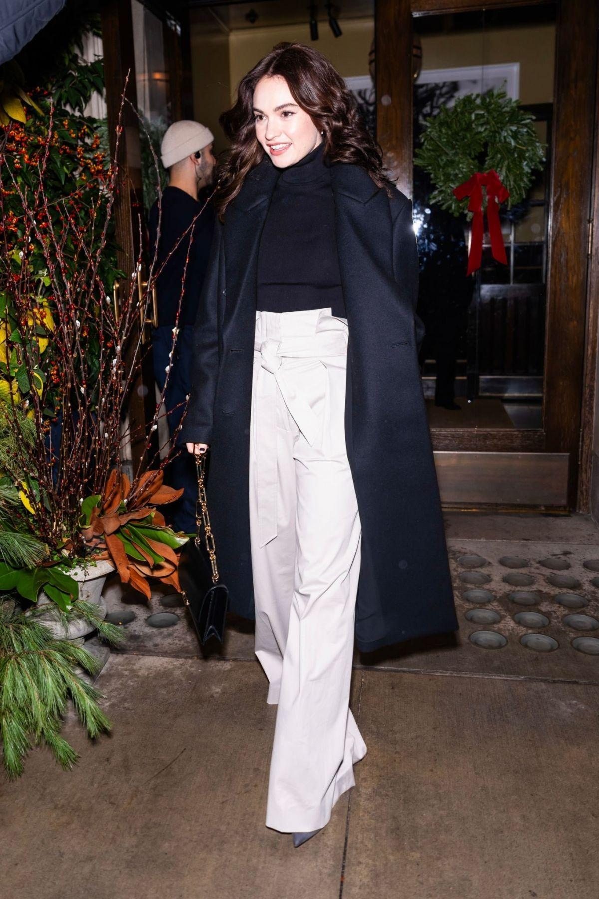 Lily James in black overcoat leaving NYC hotel