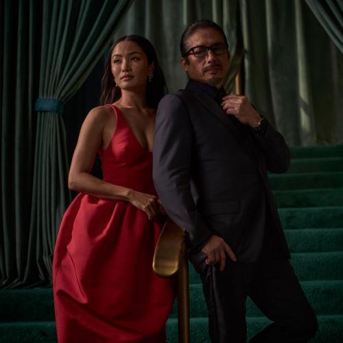 Anna Sawai in a red gown standing alongside a fellow Emmy winner, posing confidently on a green staircase.